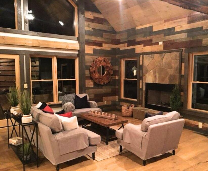 Photo of interior of log home living area with geometric exposed wood flat logs on the interior walls and wood exposed ceiling and floors