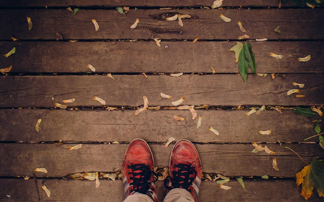 Photo of someone with red shoes standing on a wood deck